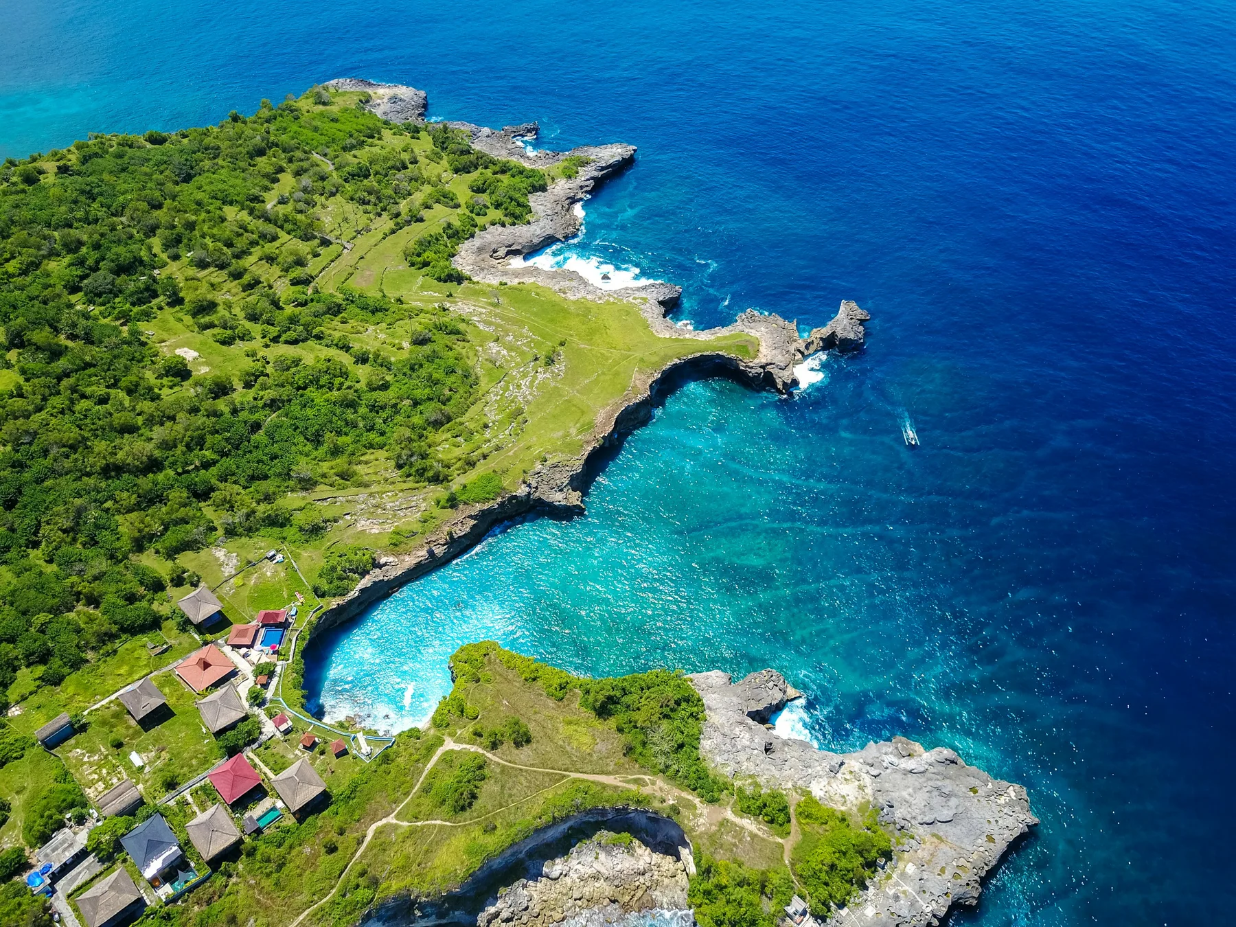 Green headland and brilliant blue water on the Nusa Ceningan coast